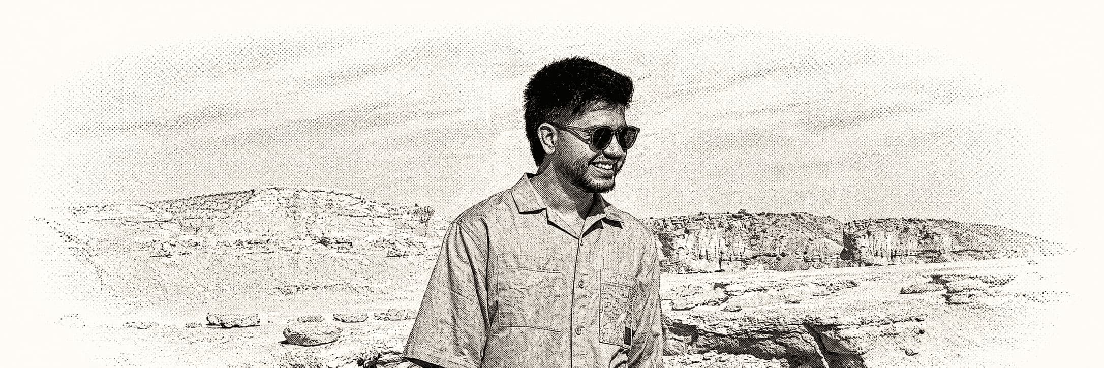 Halftone portrait of Erfan Pouya in a rocky desert landscape.